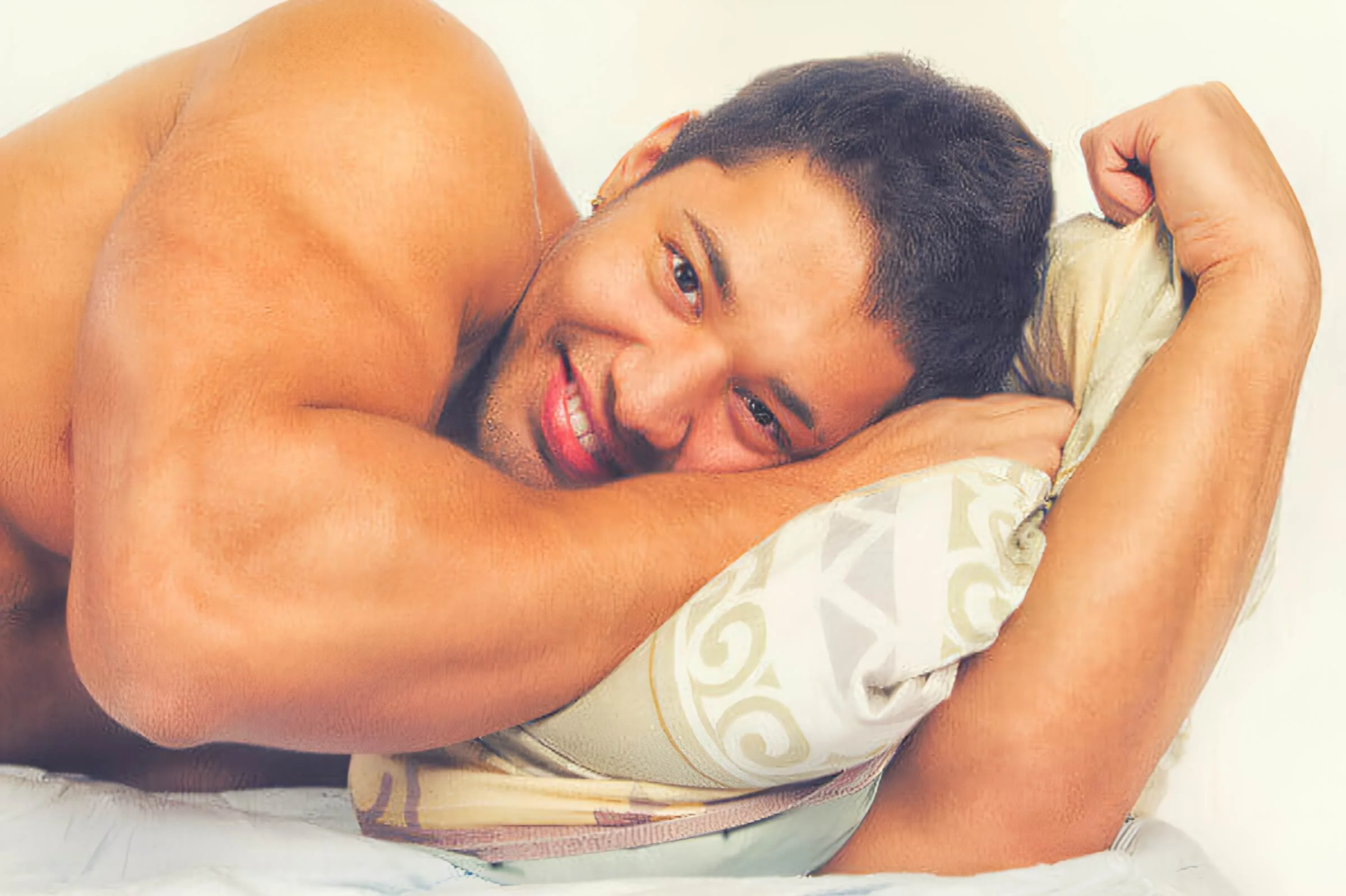 Gay Tribes Jock (Symbolbild: Ein Mann mit nacktem Oberkörper liegt auf dem Bett und lächelt in die Kamera). Gay Tribes Jock (symbolic image: a man with a bare upper body is lying on a bed and smiling at the camera).