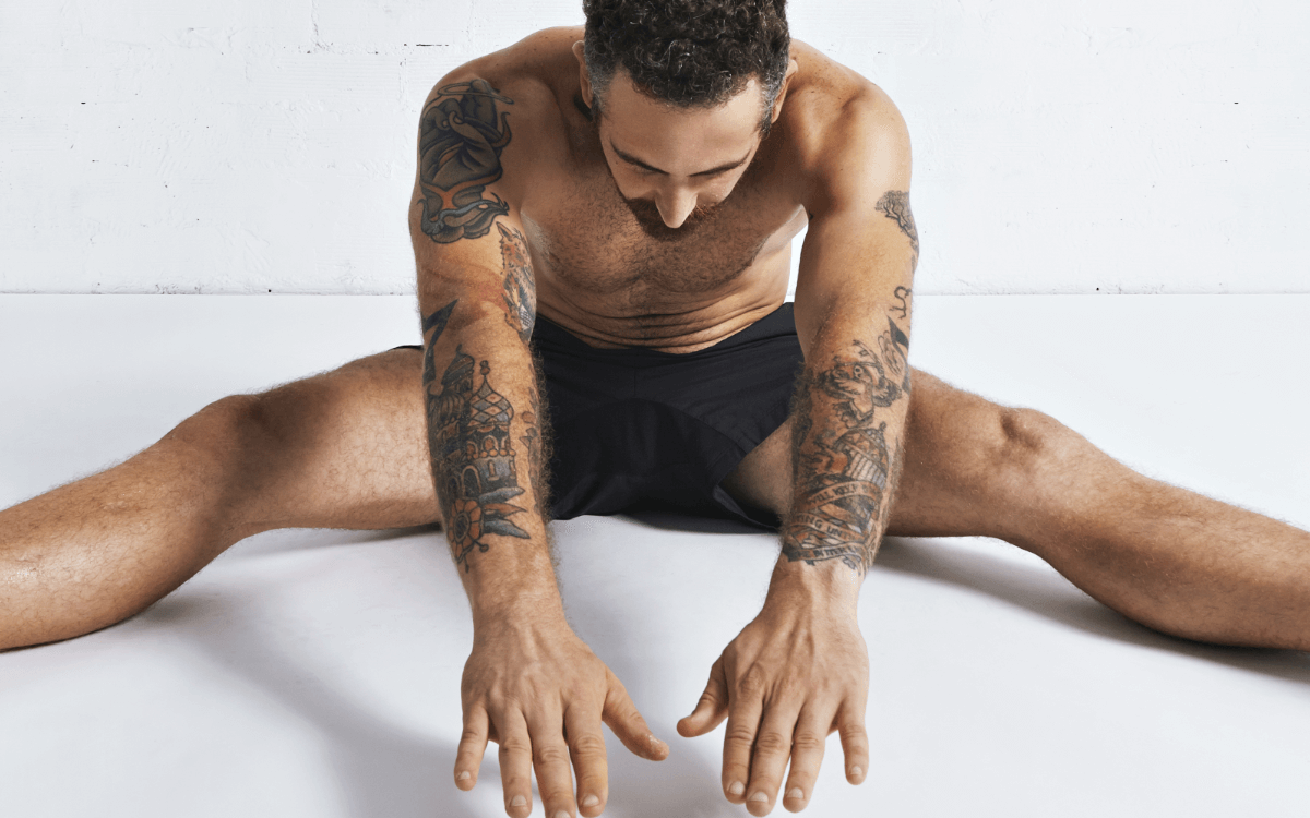 Autofellatio Symbolbild: Ein an den Armen tätowierter Mann, der nur mit Unterhose bekleidet ist, macht Dehnübungen. Englisch: Self-sucking symbol picture: a man tattooed on his arms, wearing only underpants, does stretching exercises.