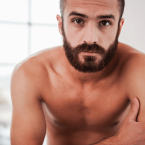 Side kein Anal - Symbolbild: Ein Mann mit nacktem Oberkörper schaut ernst in die Kamera. Englisch: Side no anal - Symbolbild: A man with a naked torso looks seriously into the camera.