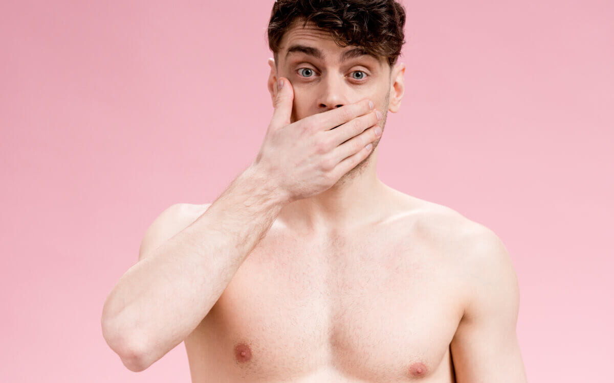 Angstspiele: Ein Mann mit freiem Oberkörper hält sich vor Entsetzen die Hand vor den Mund. Englisch: Fear play: A man with his upper body exposed covers his mouth in horror.