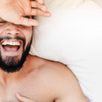Ist Masturbieren gesund? Symbolbild: Gesicht eines Mannes, der sehr glücklich im Bett liegt. Is masturbation healthy? Symbolic image: Face of a man lying very happily in bed.