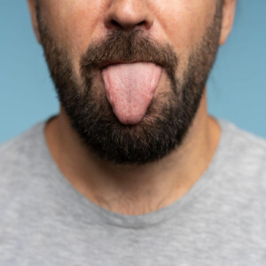 Rimming Techniken Symbolbild: Ein Mann streckt die Zunge heraus. Rimming techniques Symbolic image: A man sticks out his tongue.