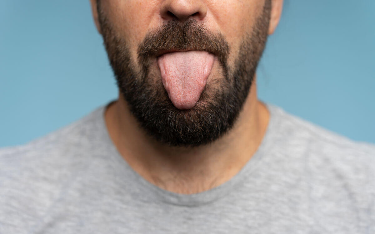 Rimming Symbolbild: Ein Mann streckt die Zunge heraus. Englisch: Rimming Symbolic image: A man sticks out his tongue