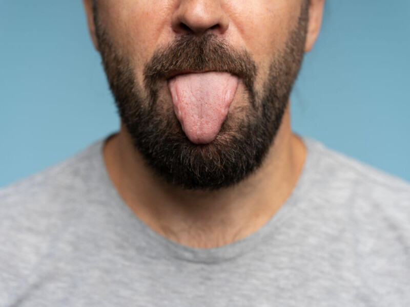Rimming Symbolbild: Ein Mann streckt die Zunge heraus. Englisch: Rimming Symbolic image: A man sticks out his tongue