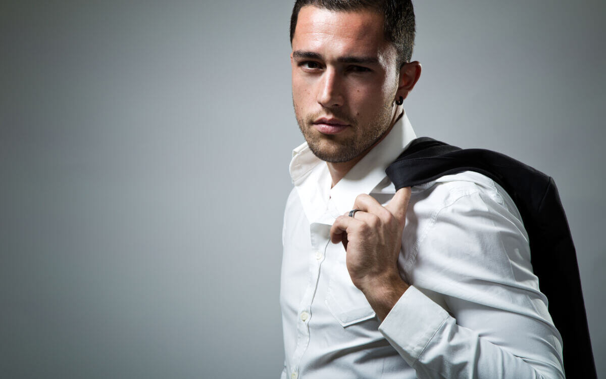 BDSM Geschichte Wenn der CEO mit seinem Assistenten “arbeitet”. Symbolbild: Ein Mann mit Hemd hat seine Anzugjacke über die Schulter gelegt. . BDSM story When the CEO “works” with his assistant. Symbolic image: A man wearing a shirt has his suit jacket draped over his shoulder.