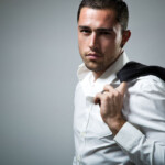 BDSM Geschichte Wenn der CEO mit seinem Assistenten “arbeitet”. Symbolbild: Ein Mann mit Hemd hat seine Anzugjacke über die Schulter gelegt. . BDSM story When the CEO “works” with his assistant. Symbolic image: A man wearing a shirt has his suit jacket draped over his shoulder.