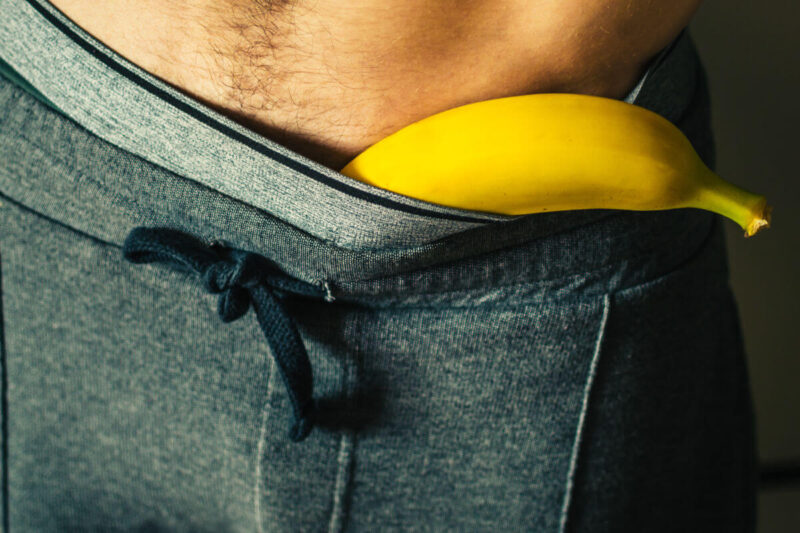 Symbolbild sicheres sounding: Ausschnitt Banane, die im Hosenbund einer Jogging-Hose steckt. Illustration of safe sounding: a slice of banana tucked into the waistband of a pair of sweatpants.