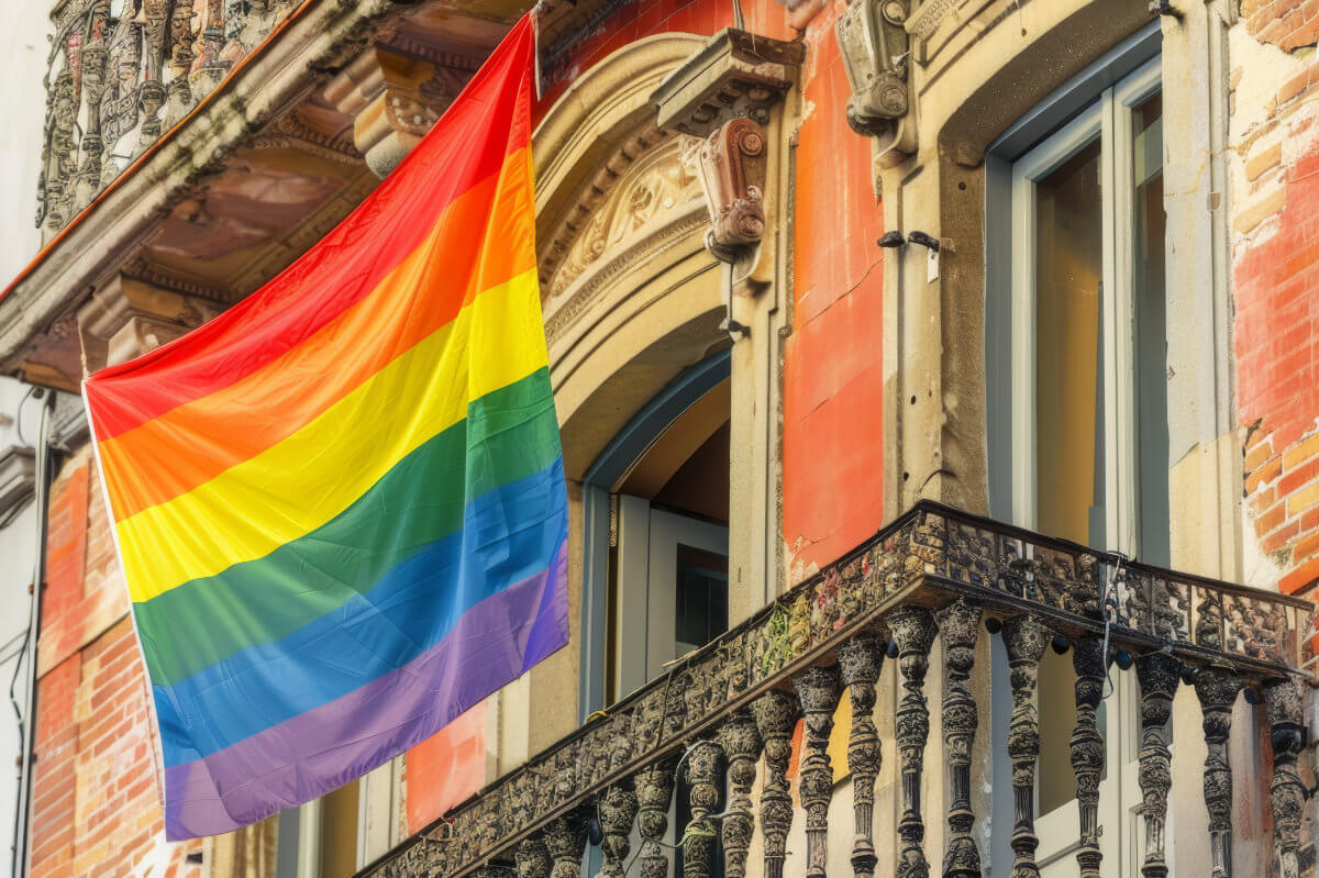CSD Geschichte: Regenbogenflagge an einem historischen Gebäude als Symbol für Pride, LGBTQIA+, Vielfalt und den Christopher Street Day. Pride History: Rainbow flag displayed on a historic building, symbolizing LGBTQIA+ pride, equality and the global Pride movement.